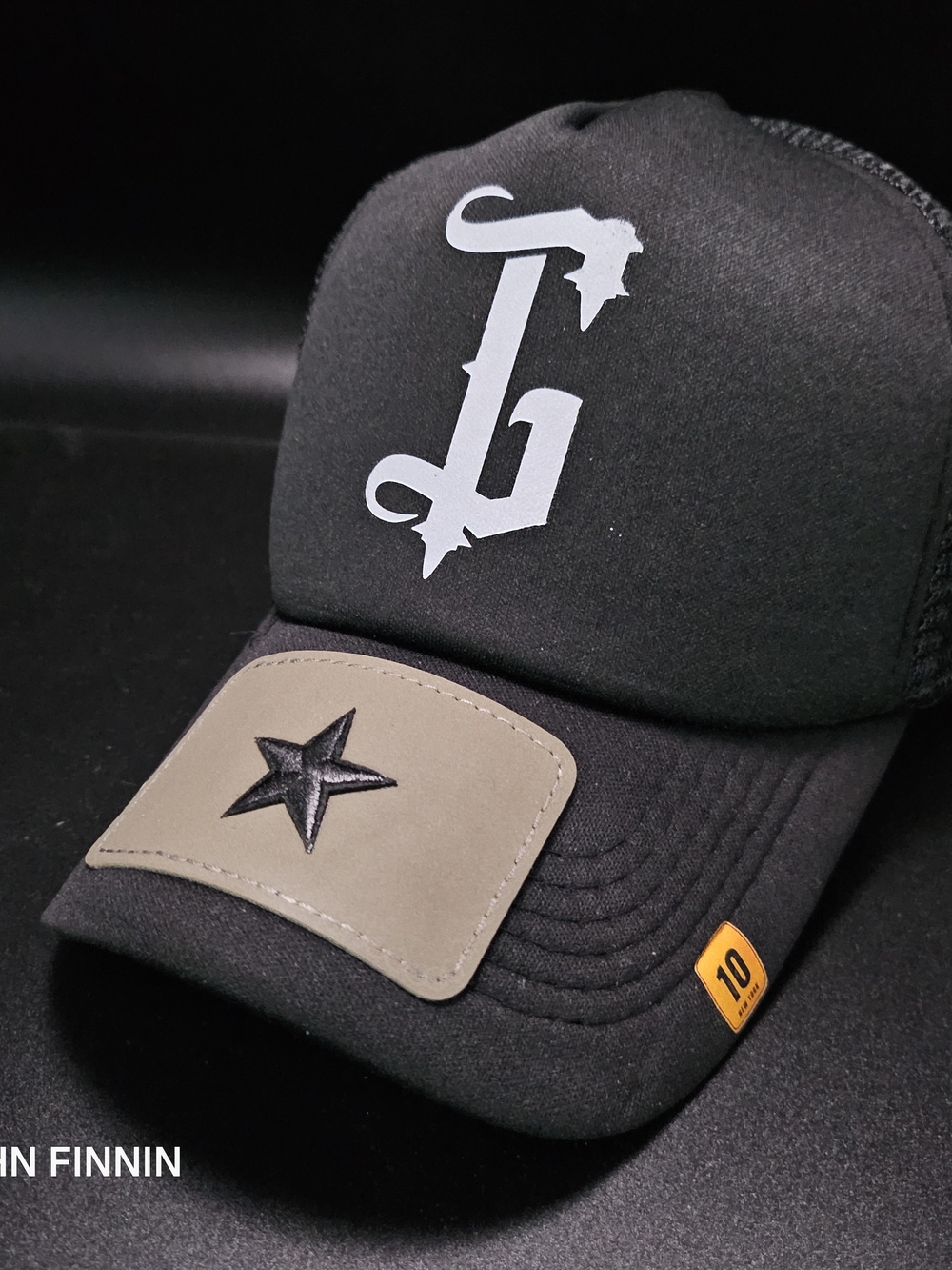 Black Trucker Cap with White Stylized 'G' and Star Patch